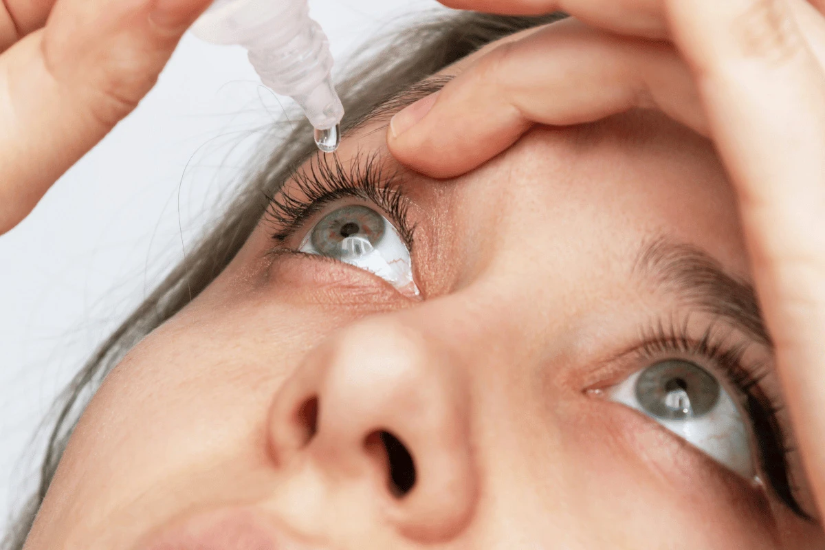 a woman putting in eye drops for dry eye