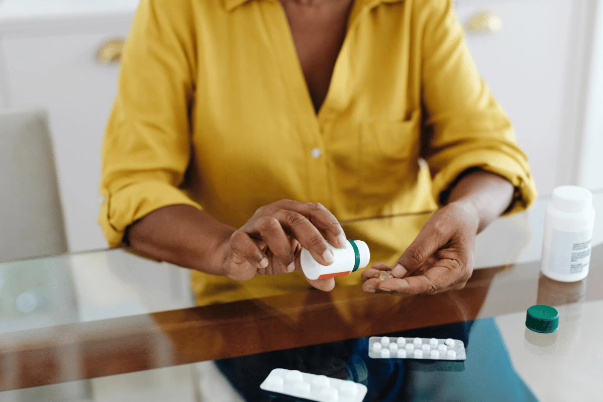 a woman sitting at a table taking medication