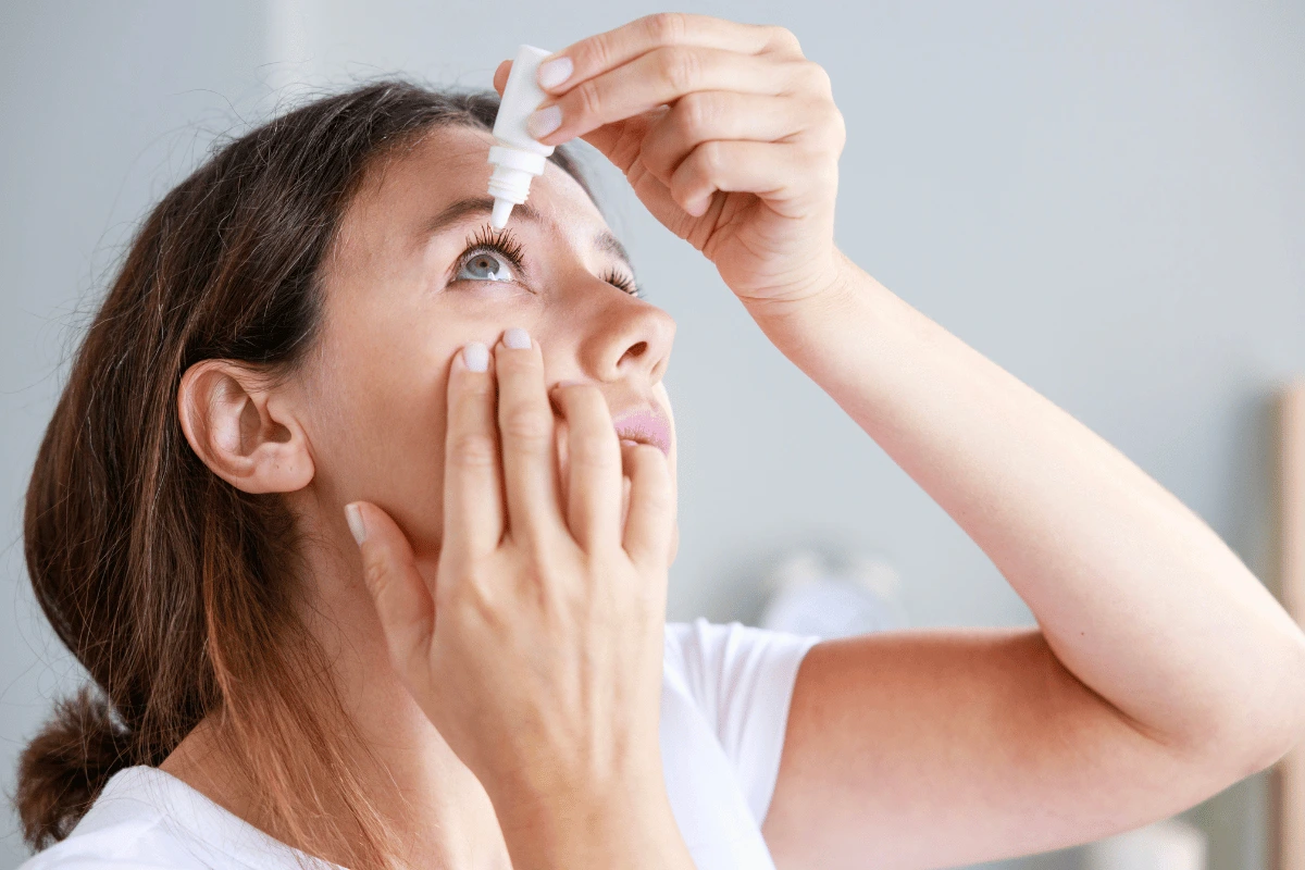 a woman putting in eye drops for dry eye