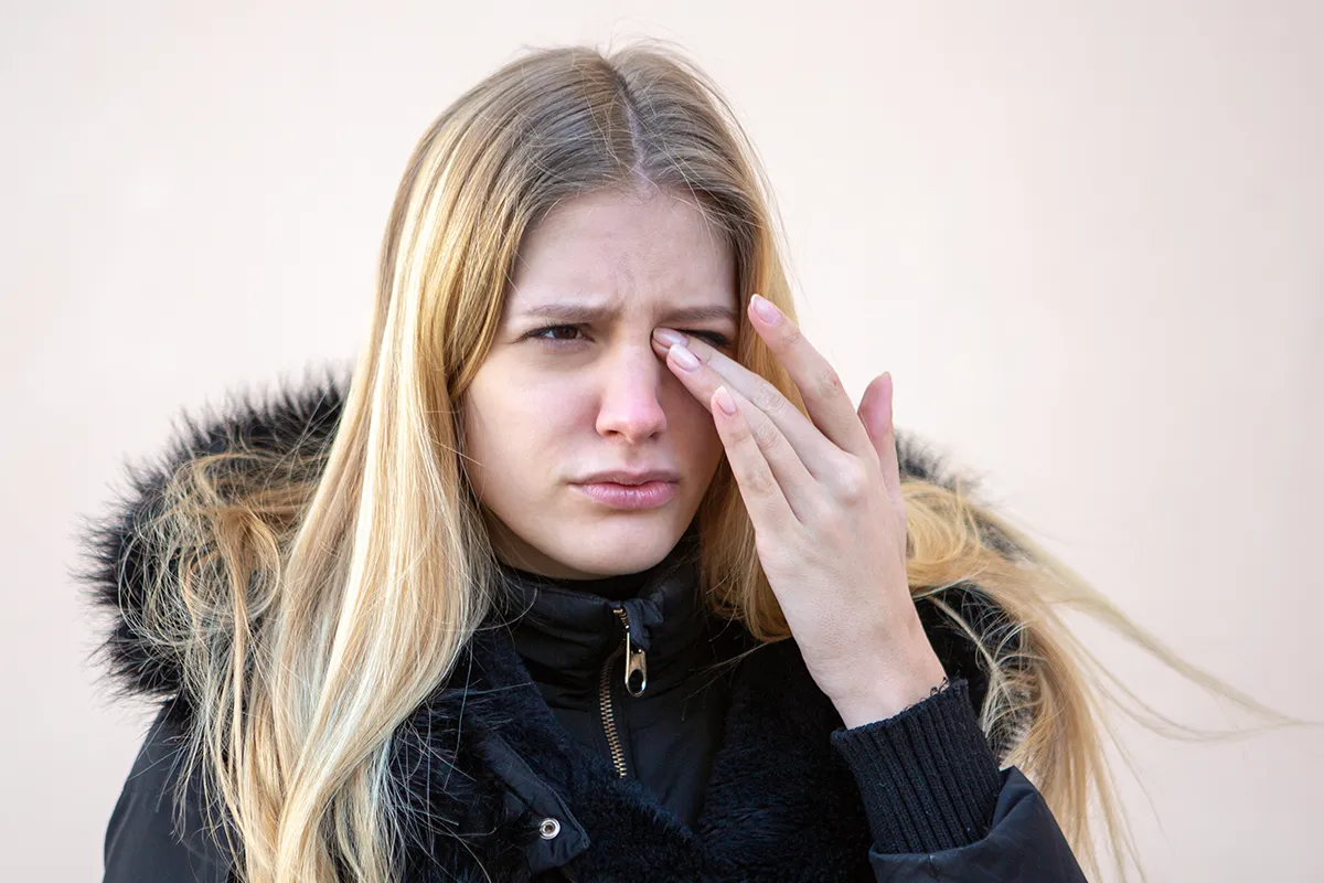 dry-eyes-in-winter a woman rubbing her eye in winter