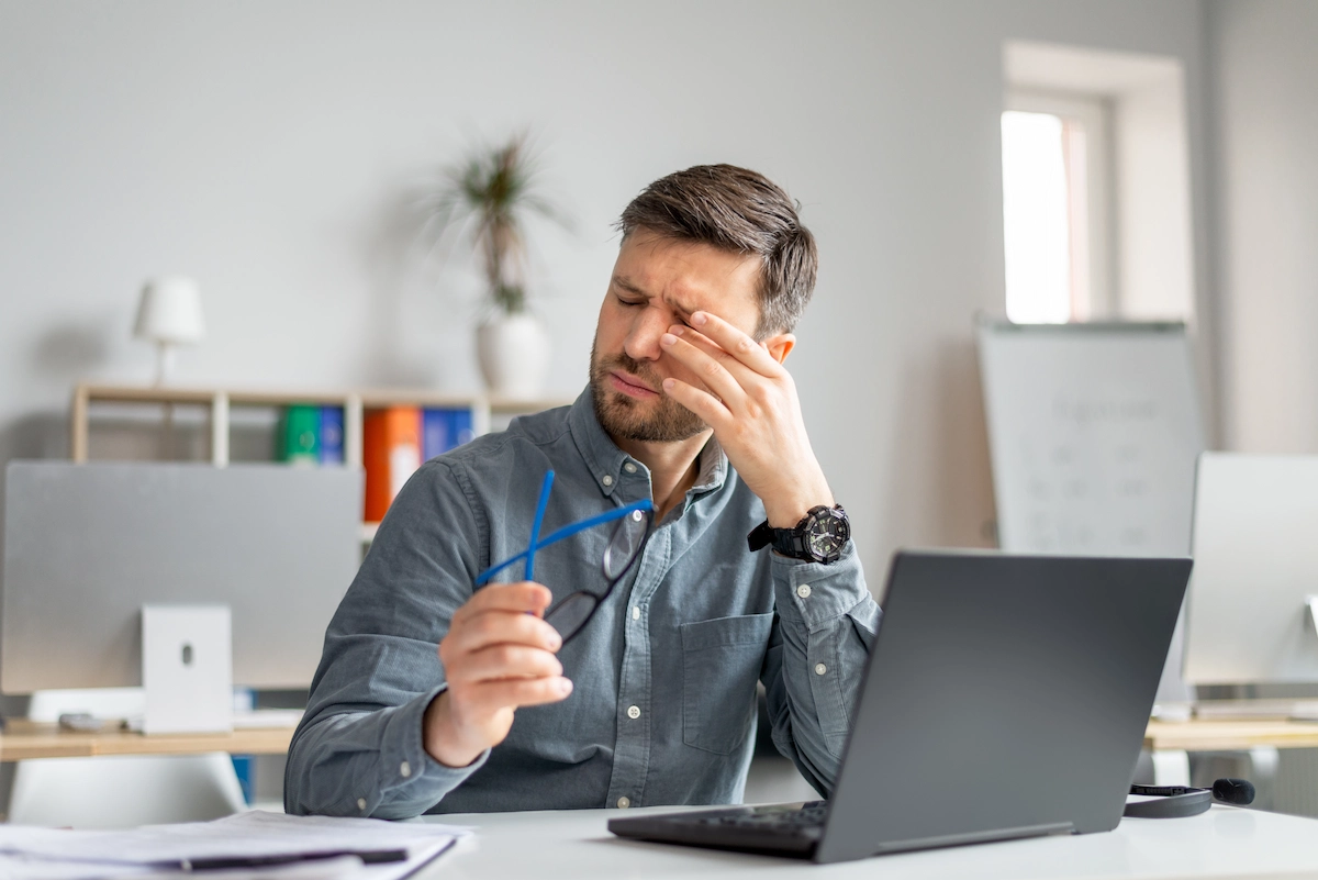 Man rubbing irritated eye